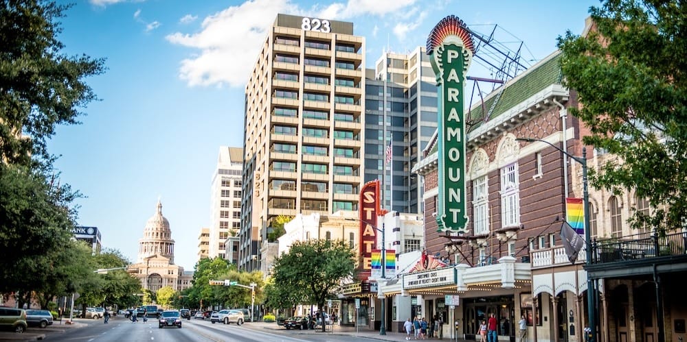 Congress Avenue in Austin, Texas, with the historic Paramount Theatre in the foreground and the Texas State Capitol visible down the street.
